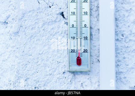 Thermomètre suspendu à maison blanche montrant moins 20 degrés celcius. Banque D'Images