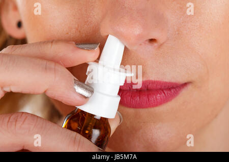 Close up photo d'une femme malade à l'aide de gouttes pour le nez Banque D'Images