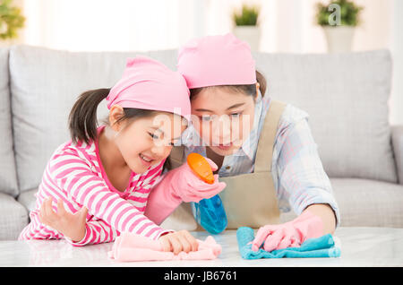 Mixed Race Chinoise Asiatique mère et fille faire le nettoyage dans la maison. Famille heureuse nettoie la chambre. Une jeune femme et un petit enfant fille de poussière Banque D'Images