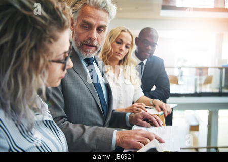 Le noir et blanc les hommes et les femmes qui travaillent avec des papiers sur le lieu de travail et de communication. Banque D'Images