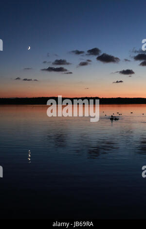 Magnifique coucher de soleil reflété sur le lac à Azur, France avec ciel de nuit claire et croissant de lune Banque D'Images