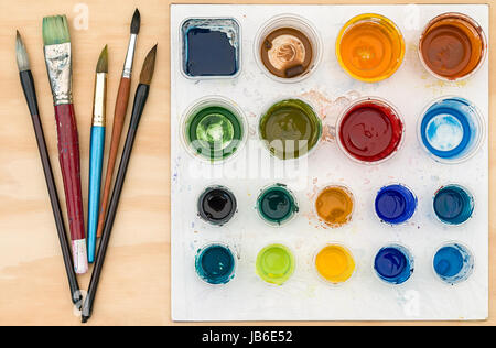Pinceaux et palette de l'artiste avec la peinture acrylique sur fond de bois Banque D'Images