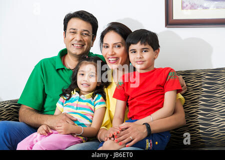 4 personnes à la maison père mère enfants garçon fille parents sitting smiling Banque D'Images