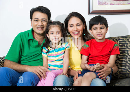 4 personnes à la maison père mère enfants garçon fille parents sitting smiling Banque D'Images