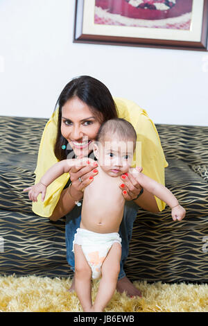 2 personnes femme adulte à la maison baby boy aider mother smiling fils marcher Banque D'Images