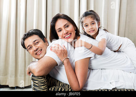 3 personnes à la maison fille famille Père Mère Enfant girl smiling canapé Banque D'Images