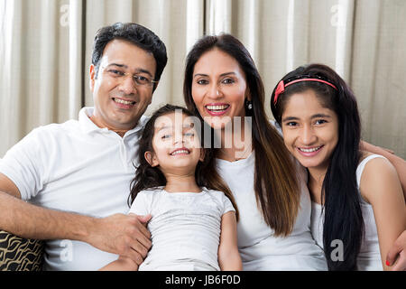 4 personnes à la maison mère filles père fille sitting smiling canapé togetherness Banque D'Images