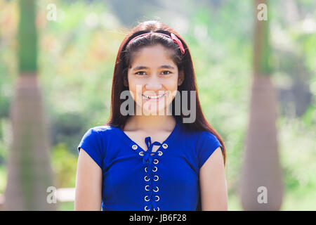 1 adolescent indien Girl standing in park smiling Banque D'Images