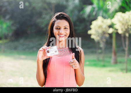 1 jeune fille teeanger indien showing Thumbs up avec carte d'identité du gouvernement aadhaar Banque D'Images