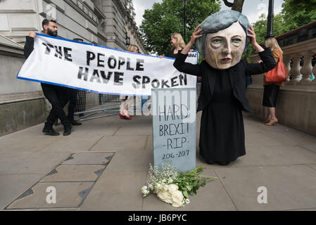 Londres, Royaume-Uni. 9 juin 2017. Après les résultats des élections ont montré qu'aucun parti n'avait la majorité, les manifestants sont venus à Westminster pour exiger que Theresa peut démissionner. Elle a l'intention de rester et d'essayer de gouverner, en s'appuyant sur les votes de la DUP, Parti lié à des paramilitaires loyalistes. Avaaz a présenté une personne avec un grand chef de la caricature Theresa Mai à Downing St à posent devant une banderole "Le peuple a parlé" et de jeter des roses blanches devant une pierre tombale avec le message 'Brexist R.I.P 2016-2017'. Credit : ZUMA Press, Inc./Alamy Live News Banque D'Images