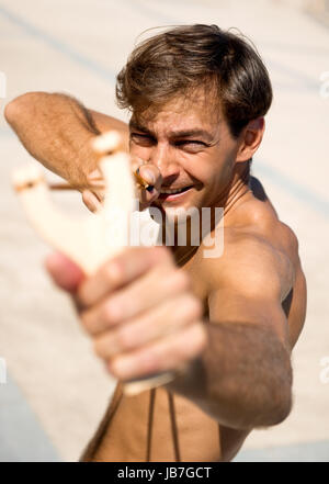 Man holding slingshot en plein air Banque D'Images