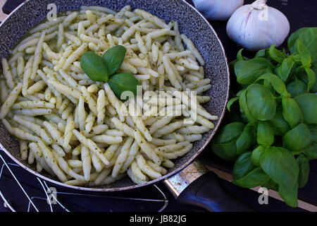 Trofie typiquement italien, les pâtes maison, sauce pesto fait avec Bâle, dans le moule sur une table rustique, d'un éclairage naturel Banque D'Images