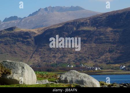 Collines escarpées au-delà des rochers et de l'entrée de marée Lochranza sur un Après-midi de printemps ensoleillé. Isle of Arran, Ecosse, printemps 2017. Banque D'Images