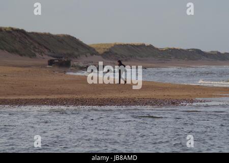 Promenade du soir le long de la plage. Embouchure de la rivière Don en premier plan, la seconde guerre mondiale 'Boîte à Pilules' et des dunes de sable en arrière-plan. Avril 2017, Aberdeen Scot. Banque D'Images