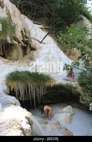 BAGNI SAN FILIPPO, ITALIE - 2 juin 2017 : deux personnes se baigner dans la piscine des sources chaudes naturelles de Bagni San Filippo en Italie, région de Toscane Banque D'Images