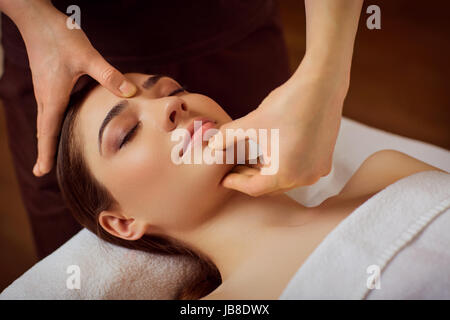 Belle femme est donné un visage massage au spa salon Banque D'Images