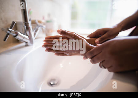 Portrait de Mère fille mains aidant tout en se lavant les mains à l'évier de salle de bains Banque D'Images