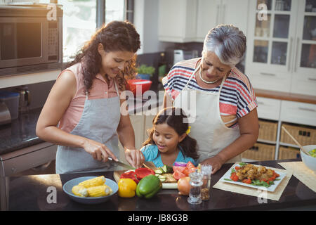 L'enseignement de mère fille à couper les légumes dans la cuisine à la maison Banque D'Images