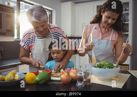 Grand-mère petite-fille d'enseignement à couper les légumes dans la cuisine à la maison Banque D'Images