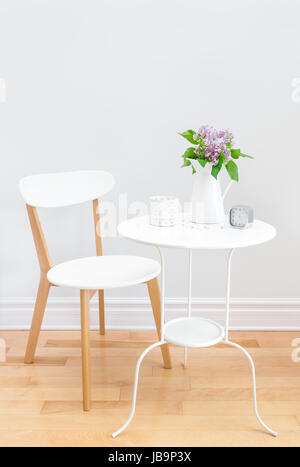 L'intérieur élégant avec table et chaise, blanc décoré d'un bouquet de lilas. Banque D'Images