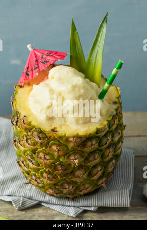 Frozen Pina Colada Cocktail dans un ananas avec une garniture Banque D'Images