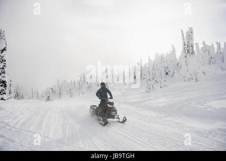 Man riding en motoneige en hiver Alpes enneigées Banque D'Images