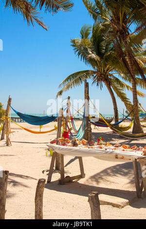 Belle plage tropicale avec des hamacs et des conques en vente sur l'île de Caye Caulker sur la barrière de corail dans la mer des Caraïbes Banque D'Images