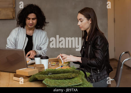 Des collègues ayant repas ensemble at desk in office Banque D'Images