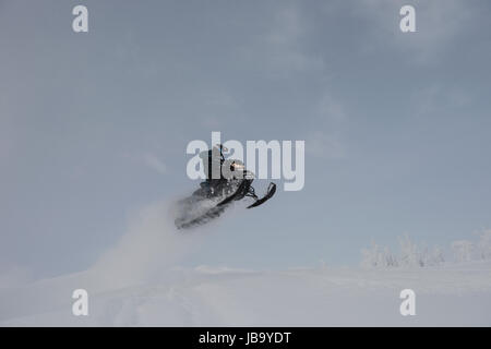 Man riding en motoneige en hiver Alpes enneigées Banque D'Images