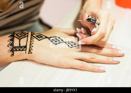 Jeune femme artiste mehendi henné sur la main peinture Banque D'Images