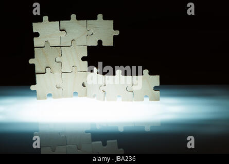 Puzzle en bois et l'éclairage de l'arrière-plan. Pièces empilées verticalement. Banque D'Images