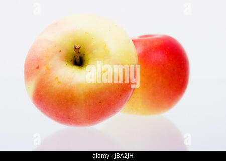Deux pommes rouges bien mûrs sur une surface réfléchissante Banque D'Images