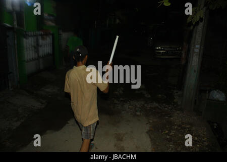 Bekasi Regency, Indonésie. 10 Juin, 2017. Un certain nombre de garçons adolescents beat percussion auprès d'ex-bambou et pot de peinture lors de la sortie de personnes pour les repas avant l'aube, ou connu Sahur, wanasari, Village de Bekasi, regency, Java ouest, samedi, 10 juin 2017. Les gens de l'éveil dans le sahur saint mois du Ramadan est une tradition qui survivent encore en Indonésie dans les avancées technologiques telles que l'alarme. Credit : Tubagus Aditya Irawan/Pacific Press/Alamy Live News Banque D'Images