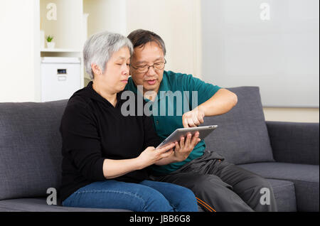 Vieille asiatique couple using tablet ensemble Banque D'Images