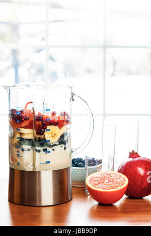 Smoothie sain ingrédients au mélangeur avec des fruits prêts à se fondre sur une table de cuisine Banque D'Images