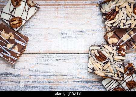 Un assortiment de morceaux d'écorce chocolat caramel organisé sur fond de bois de dessus avec copie espace Banque D'Images