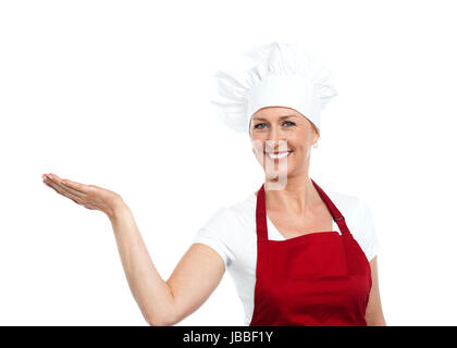 Female chef en uniforme adéquat présentant copie espace against white background Banque D'Images