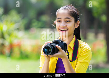 1 appareil photo photographe indien fille teeanger cliquant in park Banque D'Images