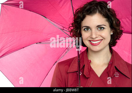 La mode jeune femme tenant un parapluie ouvert studio shot isolé. Banque D'Images