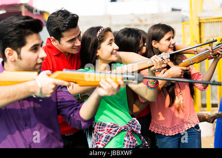 Les jeunes garçons et filles amis jouant Chasse Gun Fun Mela Banque D'Images