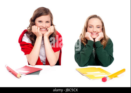 Happy young girls sitting at desk et de repos blindfold isolé sur fond blanc Banque D'Images