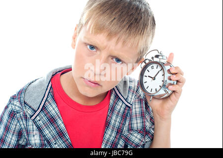 Temps de retenue pour enfants jeunes confus morceau près de son oreille. Isolés contre white Banque D'Images