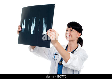 Cheerful femme médecin examinant les patients x-ray rapport. Isolé sur fond blanc. Banque D'Images