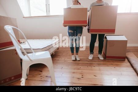 Cropped shot of young couple avec de grandes boîtes de carton déménagement au nouveau lieu. Homme et Femme transportant de grandes boîtes et le déménagement dans maison neuve. Banque D'Images