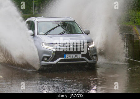 Les voitures qui circulent sur des routes inondées dans Tarleton, Lancashire, Royaume-Uni. Météo britannique. Inondation après des pluies torrentielles, ce qui rend difficile pour les conditions de conduite. Après une forte averse, la visibilité était extrêmement limitée, avec les flaques d'eau, l'eau de surface et un risque d'aquaplaning, avec une perte d'adhérence et réponse de la direction. Banque D'Images