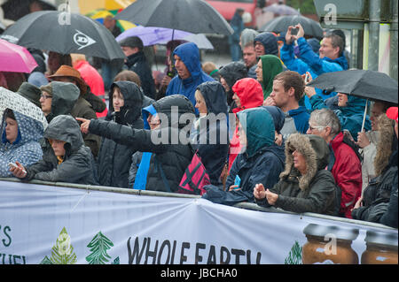 Llanwrtyd Wells, Royaume-Uni. 10 juin 2017. Spectateurs et porteur d'attendre sous la pluie pour thew départ de la course. Journée humide pour les concurrents dans l'homme V Horse Marathon. Porteur et chevaux en compétition dans les quelque 35 km homme cheval robuste sur marathon V terrain gallois. L'événement est parrainé par toute la terre et les aliments a été conçu en 1980 par Gordon Green après avoir entendu un débat à la pub Neuadd Arms, Llanwrtyd Wells, à savoir si l'homme était égale à l'exécution de cross country à distance. Credit : Graham M. Lawrence/Alamy Live News Banque D'Images