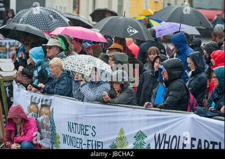 Llanwrtyd Wells, Royaume-Uni. 10 juin 2017. Spectateurs et porteur d'attendre sous la pluie pour thew départ de la course. Journée humide pour les concurrents dans l'homme V Horse Marathon. Porteur et chevaux en compétition dans les quelque 35 km homme cheval robuste sur marathon V terrain gallois. L'événement est parrainé par toute la terre et les aliments a été conçu en 1980 par Gordon Green après avoir entendu un débat à la pub Neuadd Arms, Llanwrtyd Wells, à savoir si l'homme était égale à l'exécution de cross country à distance. Credit : Graham M. Lawrence/Alamy Live News Banque D'Images