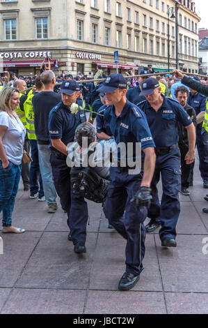 Varsovie, Pologne - 10 juin 2017 : des policiers délèvent des manifestants antigouvernementaux dans les rues de la vieille ville à l'occasion de l'anniversaire mensuel 86th de l'accident de Smolensk en avril 2010. Banque D'Images