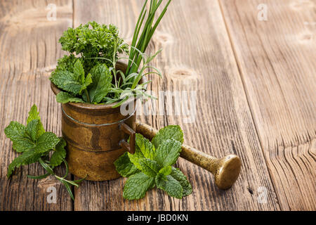 Les herbes avec du mortier sur fond de bois rustique Banque D'Images