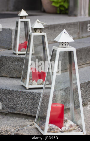 Acier Moderne lanterne avec pyramide avec bougie rouge debout sur l'éclairage des mesures de granit Banque D'Images